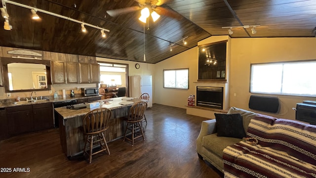 kitchen with plenty of natural light, light stone countertops, sink, and wooden ceiling