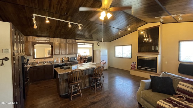 kitchen with wood ceiling, a healthy amount of sunlight, a center island, and sink