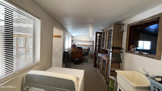 office area with vaulted ceiling, carpet, a healthy amount of sunlight, and a textured ceiling