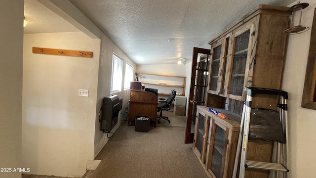 office space with lofted ceiling, heating unit, and a textured ceiling