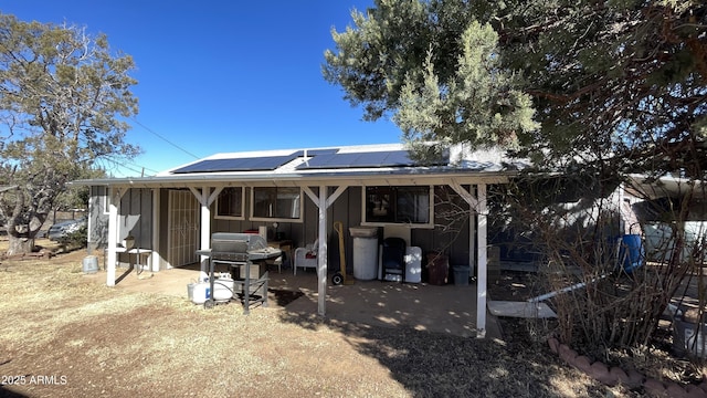 rear view of property with solar panels