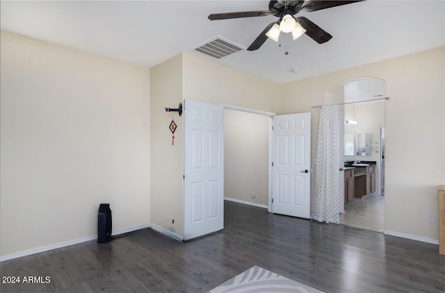 unfurnished bedroom with dark tile flooring, ceiling fan, and ensuite bath