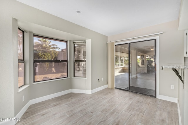 empty room featuring plenty of natural light and light hardwood / wood-style floors