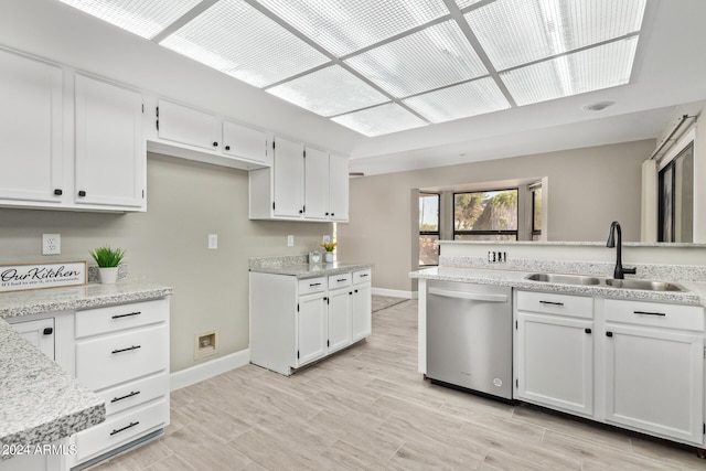 kitchen featuring white cabinets, sink, dishwasher, and light stone countertops