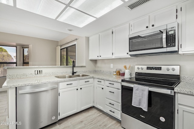 kitchen featuring white cabinets, sink, plenty of natural light, and stainless steel appliances