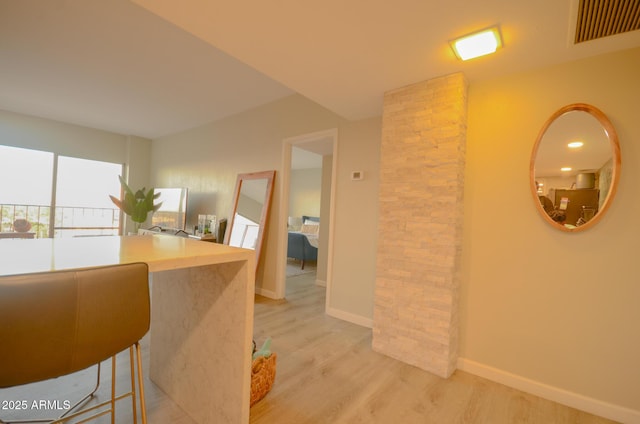 kitchen with a kitchen breakfast bar and light hardwood / wood-style flooring