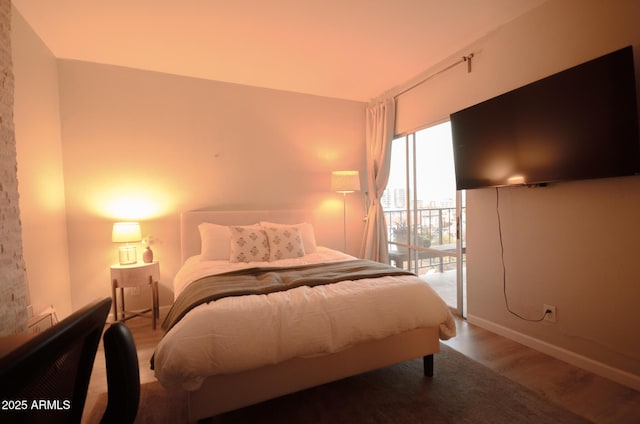 bedroom featuring hardwood / wood-style flooring and access to outside