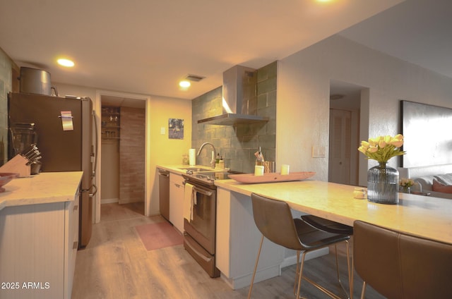 kitchen with sink, light hardwood / wood-style flooring, backsplash, stainless steel appliances, and exhaust hood