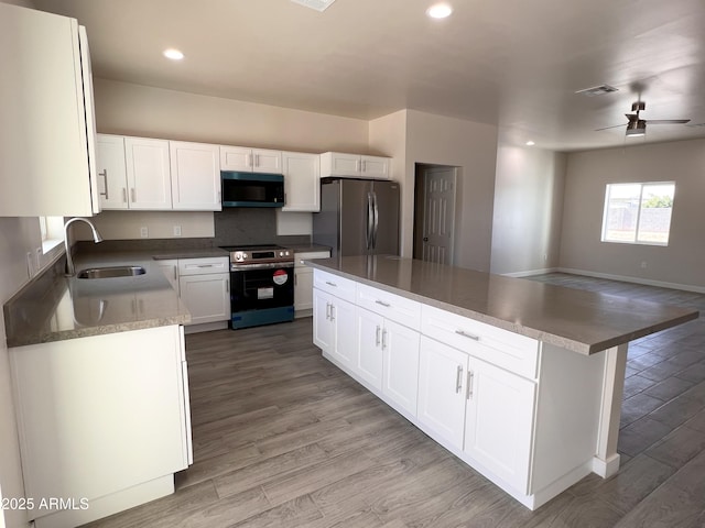 kitchen with light wood-style flooring, visible vents, stainless steel appliances, and a sink