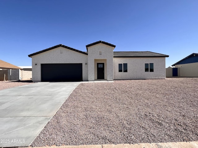 view of front of house with driveway, an attached garage, and stucco siding