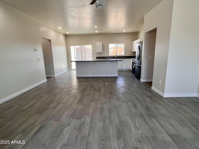 kitchen featuring dark wood finished floors, dark countertops, visible vents, open floor plan, and white cabinets