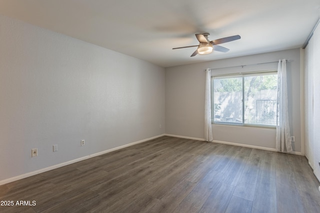 empty room featuring baseboards, a ceiling fan, and dark wood-type flooring