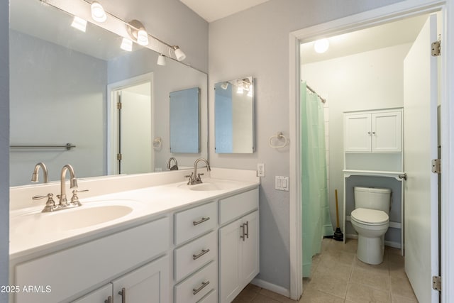 bathroom with a sink, tile patterned flooring, toilet, and double vanity