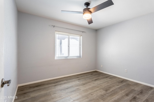 empty room with a ceiling fan, baseboards, and wood finished floors