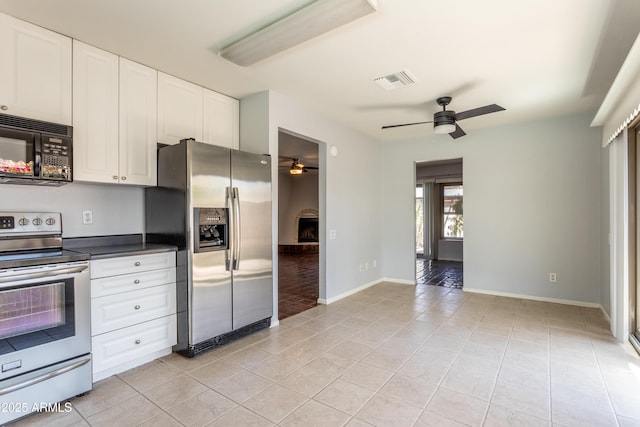 kitchen with visible vents, dark countertops, a ceiling fan, light tile patterned floors, and stainless steel appliances