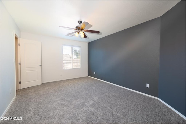 carpeted spare room featuring ceiling fan