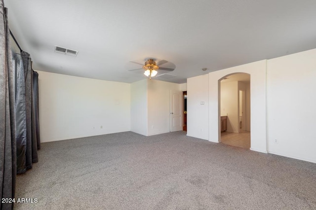 empty room with ceiling fan and light carpet