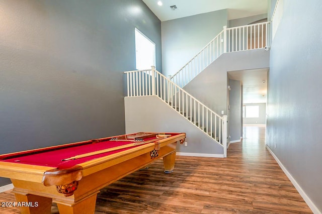 recreation room featuring hardwood / wood-style floors, pool table, plenty of natural light, and a towering ceiling