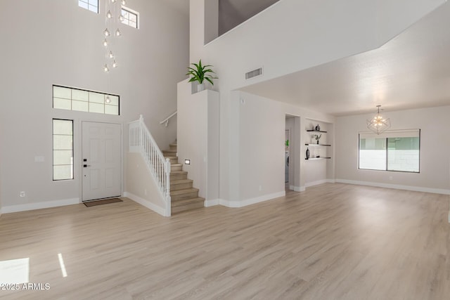 742 W Vineyard Plains Dr, San Tan Valley, AZ 85143 - foyer with a chandelier, stairway, a high ceiling, light wood-style floors, and healthy amount of natural light