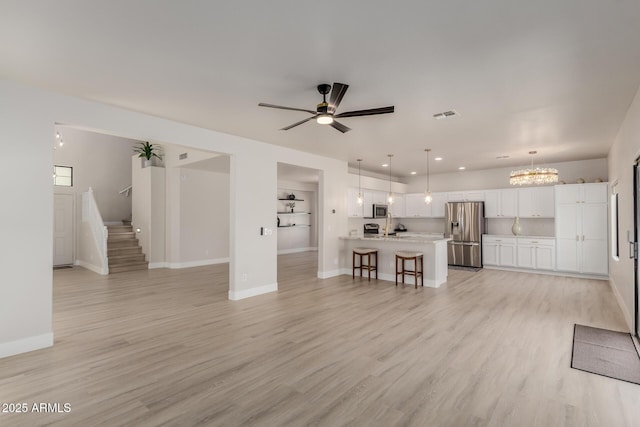 742 W Vineyard Plains Dr, San Tan Valley, AZ 85143 - living room featuring light wood finished floors, a chandelier, ceiling fan, recessed lighting, and stairs