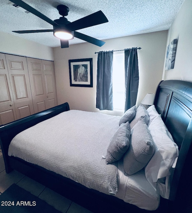 bedroom with a closet, ceiling fan, and a textured ceiling