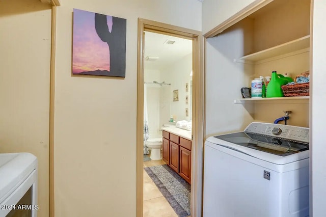 laundry room with washing machine and dryer and light tile patterned floors