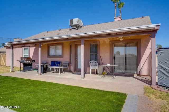 back of property with a yard, a patio, and central air condition unit