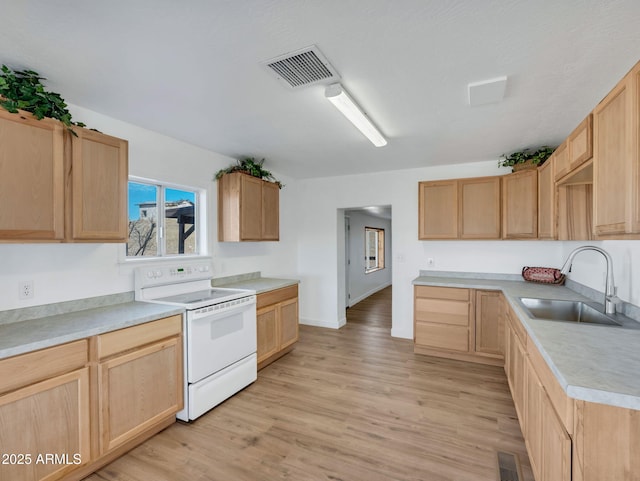 kitchen featuring white electric range oven, light brown cabinets, visible vents, and a sink