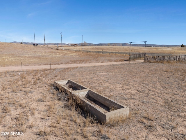 view of yard with fence and a rural view