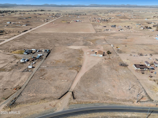 birds eye view of property featuring a rural view, a mountain view, and view of desert