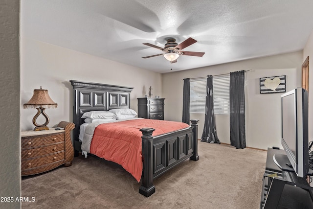 carpeted bedroom featuring ceiling fan and a textured ceiling