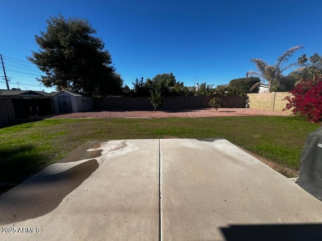 view of yard featuring a storage unit and a patio area