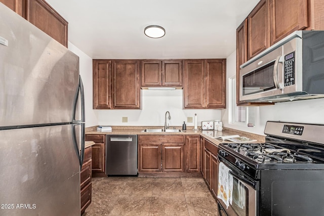 2019 W Stella Ln, Phoenix, AZ 85015 - kitchen featuring appliances with stainless steel finishes, a sink, light countertops, and brown cabinetry