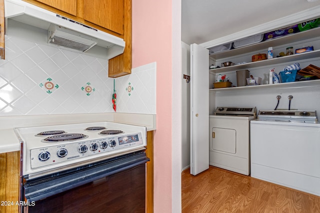 kitchen with light wood-type flooring, white electric stove, and tasteful backsplash