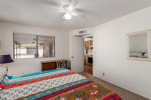 bedroom featuring ceiling fan, a textured ceiling, and carpet