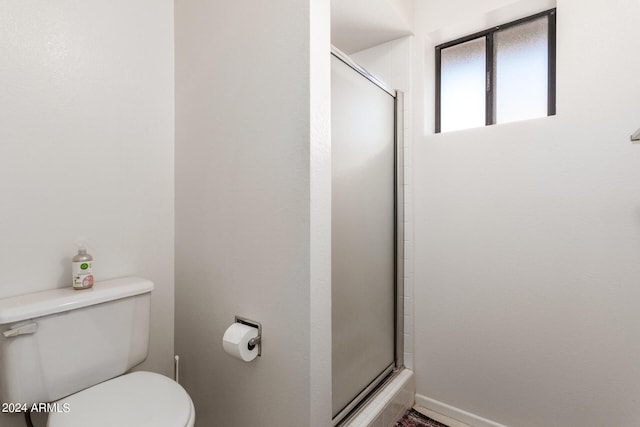 bathroom with an enclosed shower and toilet