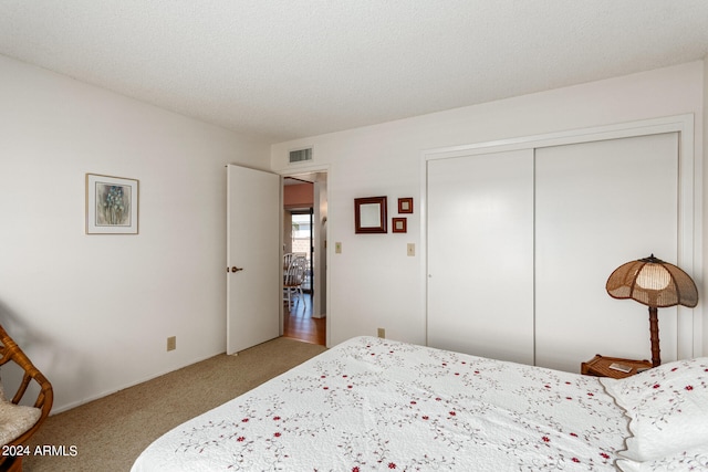 bedroom with light carpet, a closet, and a textured ceiling