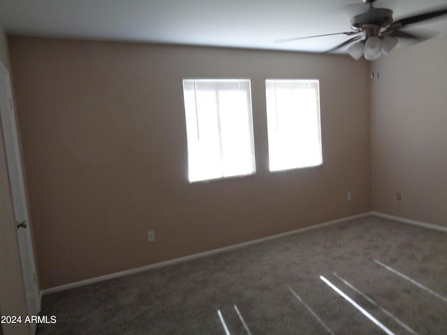 carpeted empty room featuring a ceiling fan and baseboards