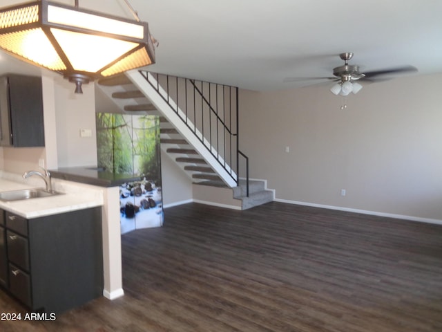 kitchen featuring baseboards, dark wood-type flooring, ceiling fan, and a sink