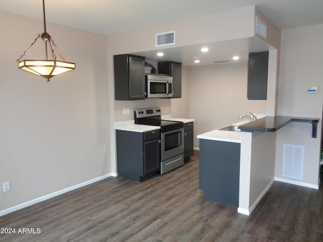 kitchen with a sink, a peninsula, visible vents, and stainless steel appliances