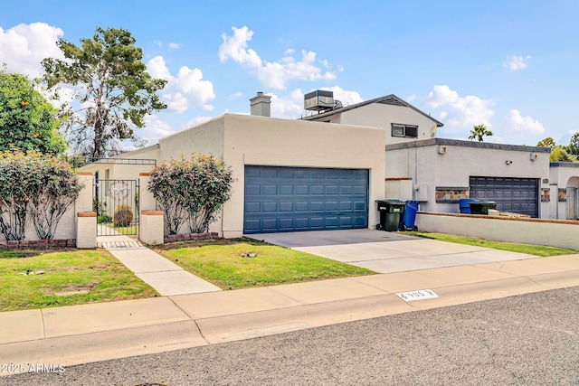 view of front of house featuring stucco siding, concrete driveway, a garage, and a gate