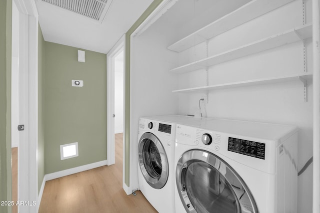 laundry room featuring visible vents, baseboards, washing machine and dryer, laundry area, and light wood-style flooring