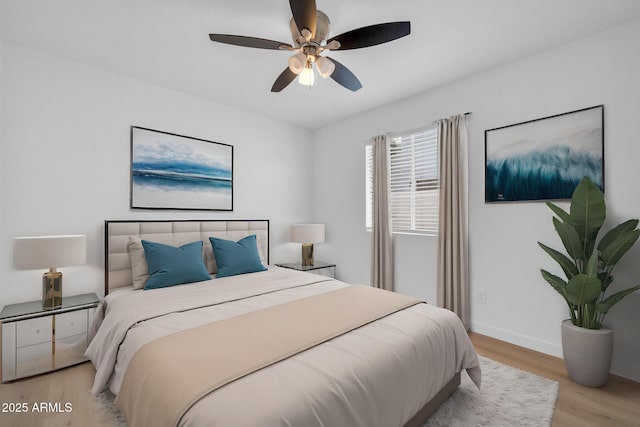 bedroom with a ceiling fan, light wood-type flooring, and baseboards