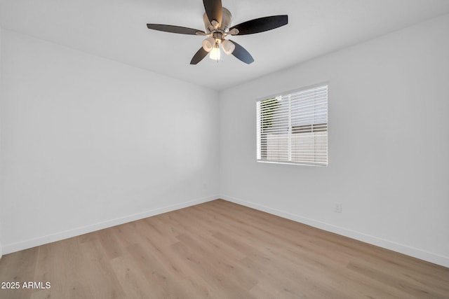 empty room featuring light wood-type flooring, baseboards, and a ceiling fan