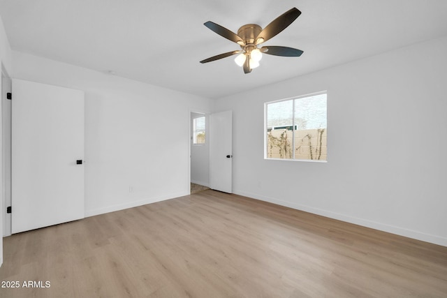 unfurnished room featuring baseboards, light wood-style floors, and ceiling fan