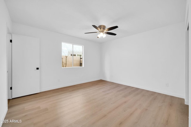 empty room with a ceiling fan, light wood-type flooring, and baseboards