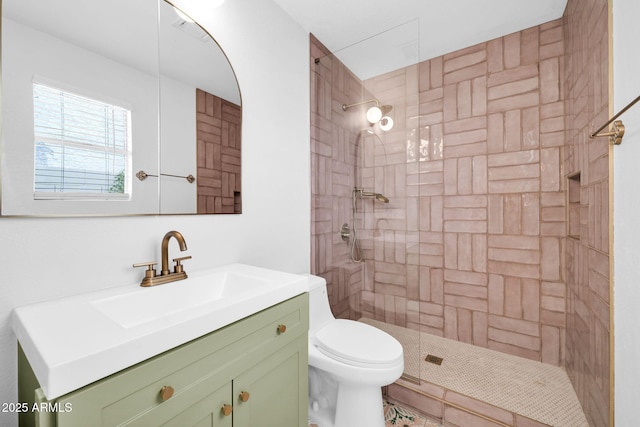 full bath with vanity, toilet, and a tile shower