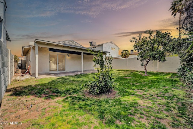 yard at dusk featuring a patio and a fenced backyard