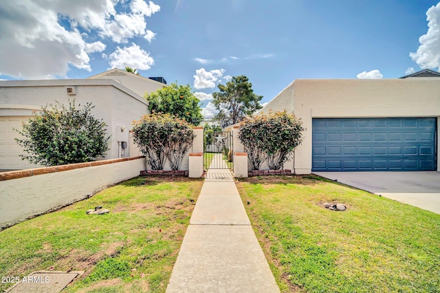 view of front of property with a front yard, a gate, driveway, and stucco siding