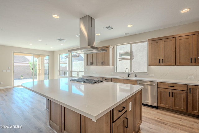 kitchen with a center island, light hardwood / wood-style floors, sink, and appliances with stainless steel finishes